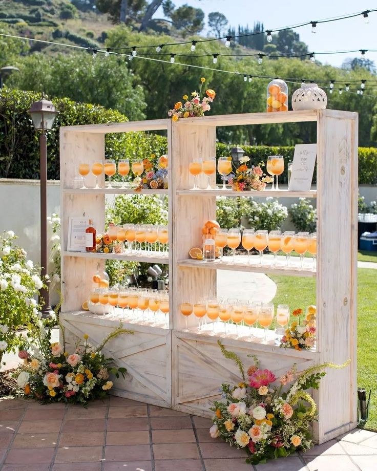 an outdoor display with oranges and flowers on the outside, surrounded by string lights