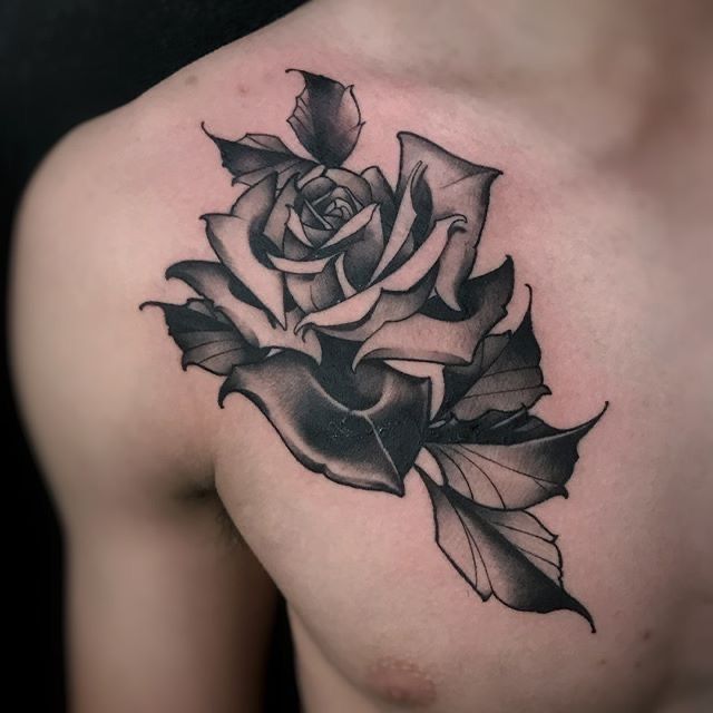 a black and white rose tattoo on the chest