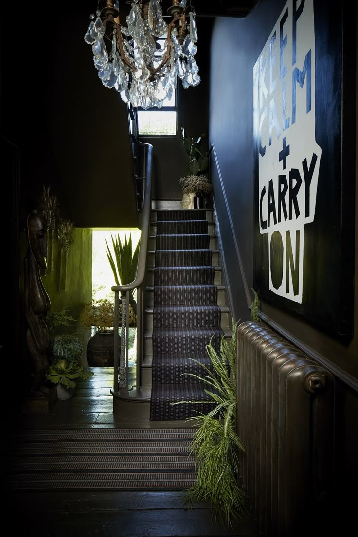 a staircase leading up to the second floor with chandelier hanging from it's ceiling