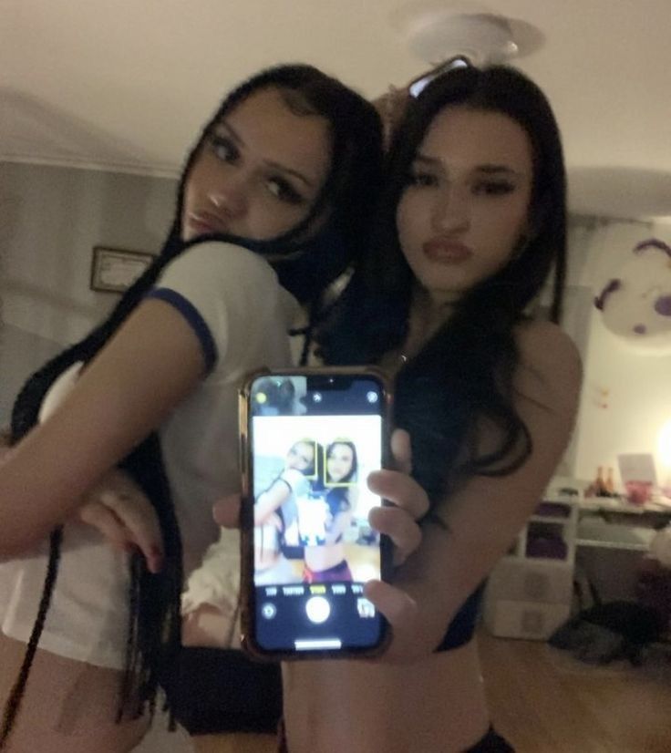 two young women taking a selfie with their cell phone