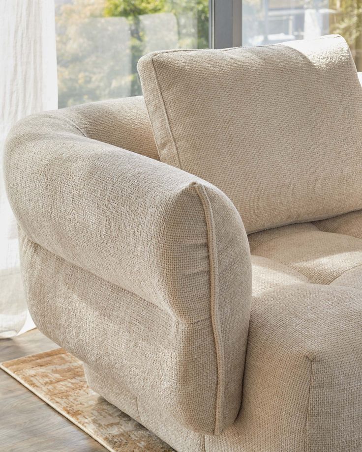 a beige chair sitting in front of a window