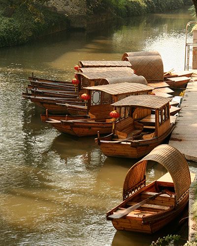 several wooden boats are docked on the water