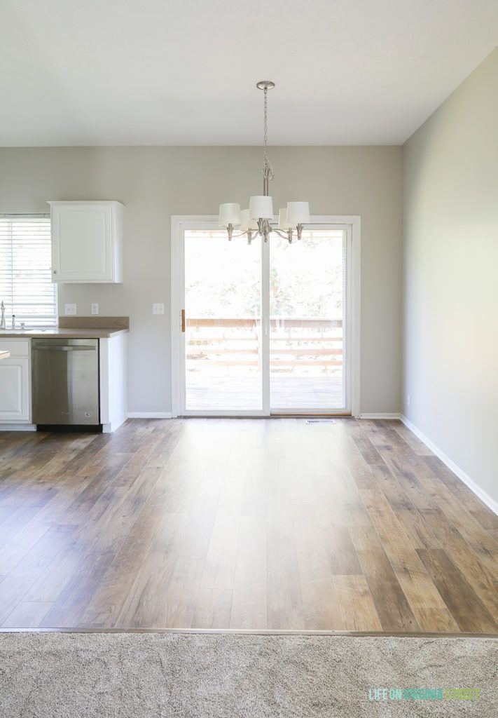 an empty living room with hard wood floors and sliding glass doors that lead to a balcony