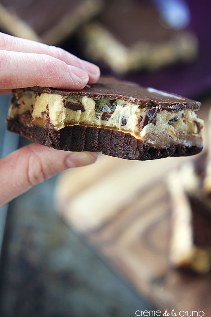 a hand holding a piece of chocolate and cheese sandwich