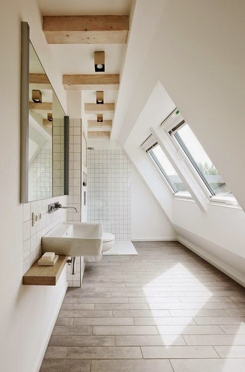 a bathroom with white walls and tile flooring next to a skylighted window