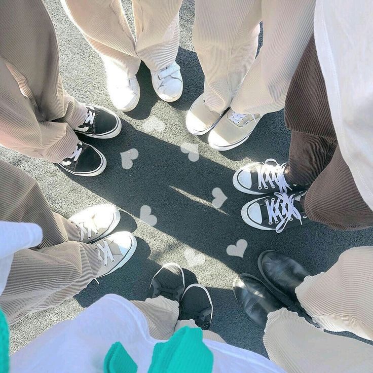 several people standing in a circle with their feet up on the ground wearing mickey mouse shoes