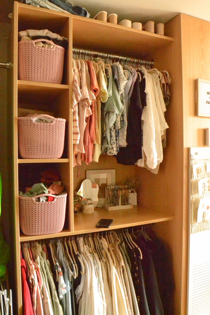 an organized closet with clothes and baskets