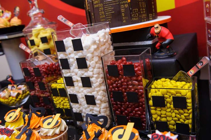 candy bar with lots of candies and cupcakes on display in plastic containers