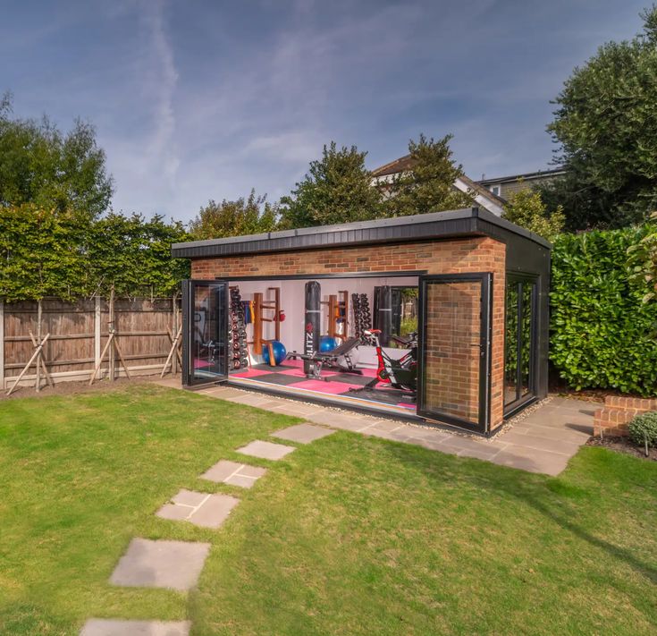 a garden shed with its doors open on the grass