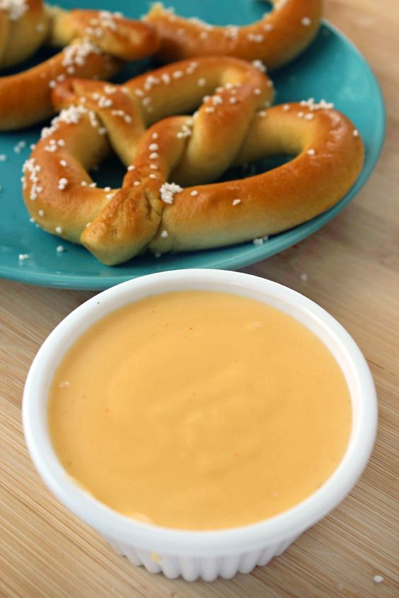 some pretzels are sitting on a plate next to a bowl of dipping sauce