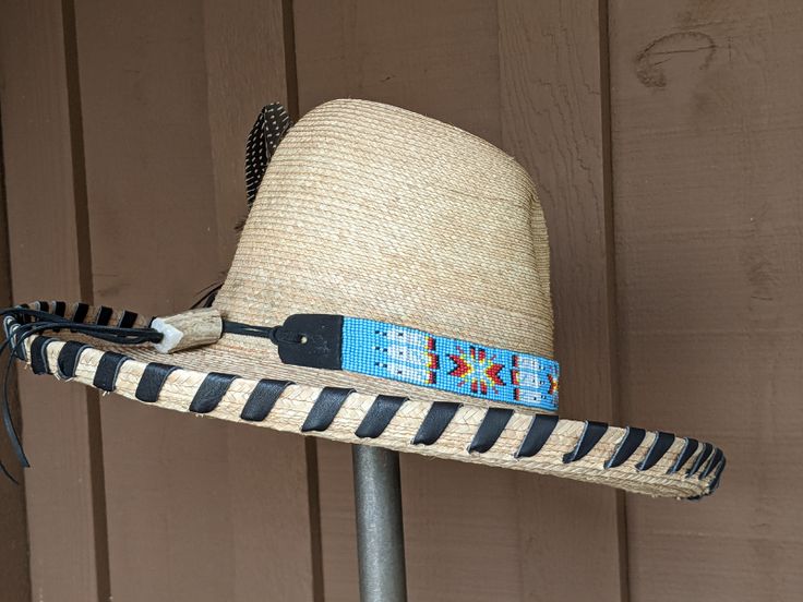 The Renegade Gus Palm Hat has a 4" brim and 5 1/4" crown. Super comfortable with a sweat band on the inside. Hand laced in black leather lace. Beautiful blue beaded hatband is secured on the hat and the back of the band has a deer antler bead. Accented with a Concho and Guinea feathers. Note: Hats are made to order. Please allow up to 4 weeks for your hat to ship Adjustable Custom Top Hat For Country Events, Adjustable High Crown Sun Hat For The Beach, Adjustable High Crown Sun Hat For Beach, Adjustable Hats For Kentucky Derby Festival, Adjustable Top Hat With Short Brim For Festivals, Adjustable Brimmed Top Hat For Rodeo, Adjustable Western Top Hat For Kentucky Derby, Adjustable Brimmed Top Hat For Western-themed Events, Adjustable High Crown Straw Hat For Kentucky Derby