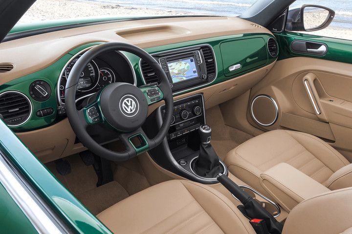 the interior of a green and beige car with dashboard, steering wheel and dash board