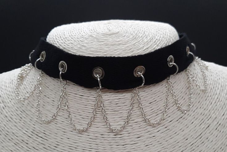 This gothy, punky choker is made from cotton ribbon set with eyelets running along the middle. The silver plated chain hangs in loops from rings attached through the eyelets and sits elegantly on the collar line.  The choker can be adjusted in length using the extender chain.   Allergy Information  I take customer care very seriously and make sure that all my jewellery is Nickel free.  * All items come in gift-wrapped jewellery box free of charge * Emo Metal Choker For Festivals, Emo Style Metal Choker For Festivals, Gothic Metal Choker For Concerts, Gothic Chain Choker For Party, Silver Emo Choker For Alternative Fashion, Silver Gothic Choker For Concert, Alternative Style Silver Choker For Concert, Metal Emo Choker For Alternative Fashion, Silver Emo Choker For Concert