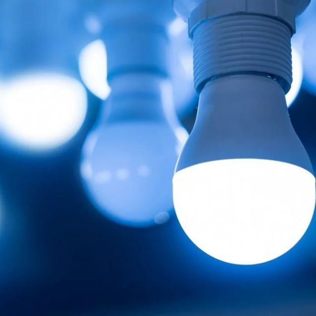 several light bulbs are lit up with blue lights in the background and one is turned on