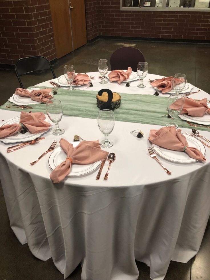 the table is set with plates, silverware and napkins