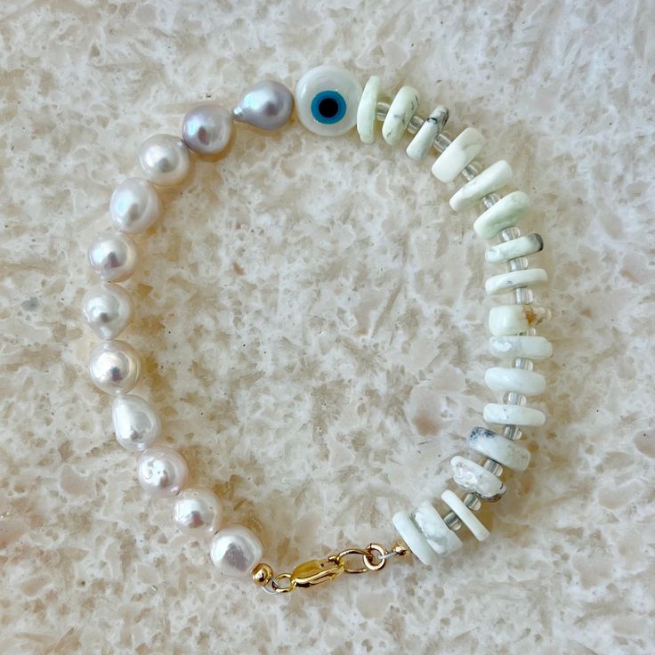 FRESHWATER PEARLS are symbolic of wisdom gained through experience. The gems are believed to offer protection, as well as attract good luck and wealth. They are well-known for their calming effects. Pearls have a way of bringing balance to your karma, bring illumination, enlightenment, and insights on a mental level. Chakras: Crown Chakra Birthstone: June Zodiac: Gemini - Pearls in round and oval shapes Coral Beads Evil Eye Bead Gold Filled Lobster Clasp and Jump Ring *Pearls are unique and one Holistic Round Beads Jewelry For Gifts, Holistic Round Beads Jewelry Gift, Elegant Good Luck Bracelets With Natural Stones, Good Luck Jewelry Bracelet With Natural Stones, Adjustable Gemstone Beads Jewelry For Blessing, Spiritual Jewelry With Stones For Meditation, White Spiritual Jewelry With Stones, Holistic Stones Jewelry For Meditation, Spiritual White Stone Jewelry