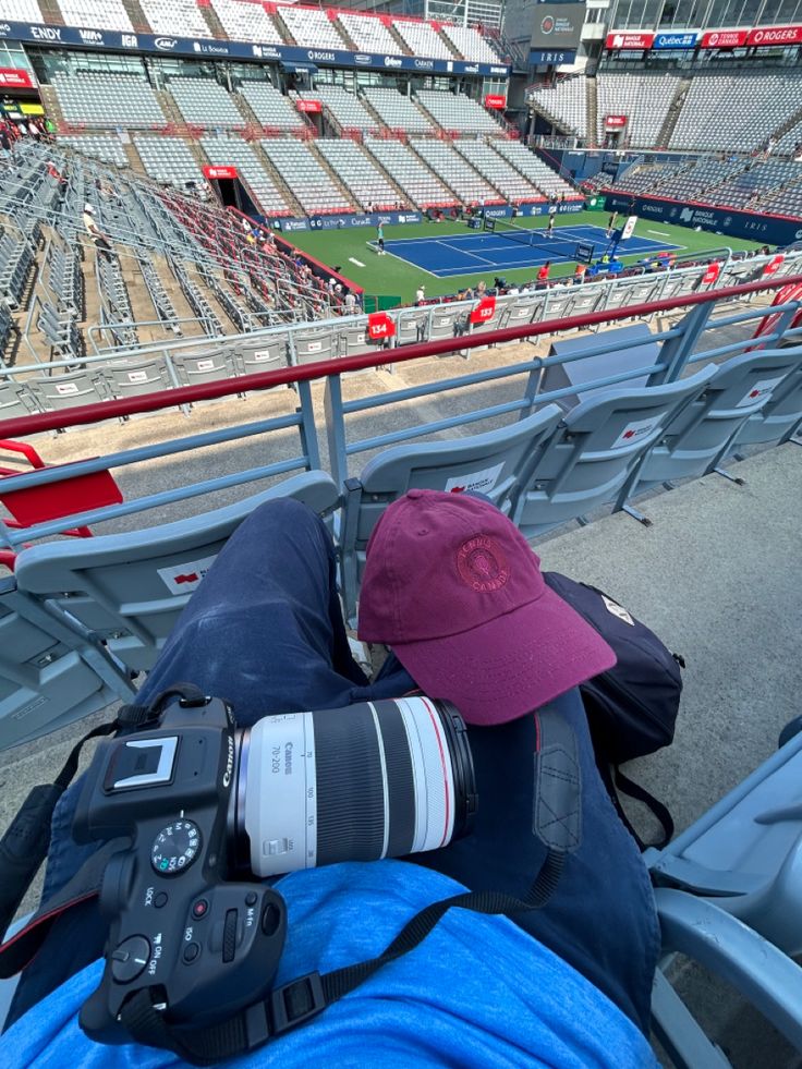 a person with a camera taking pictures at a stadium