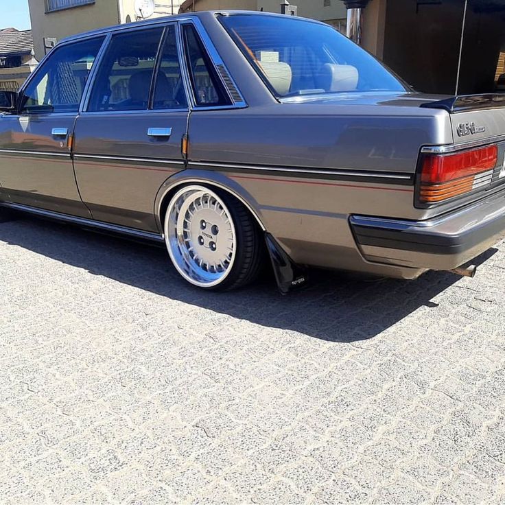 a car parked in front of a building with its door open and it's rims missing