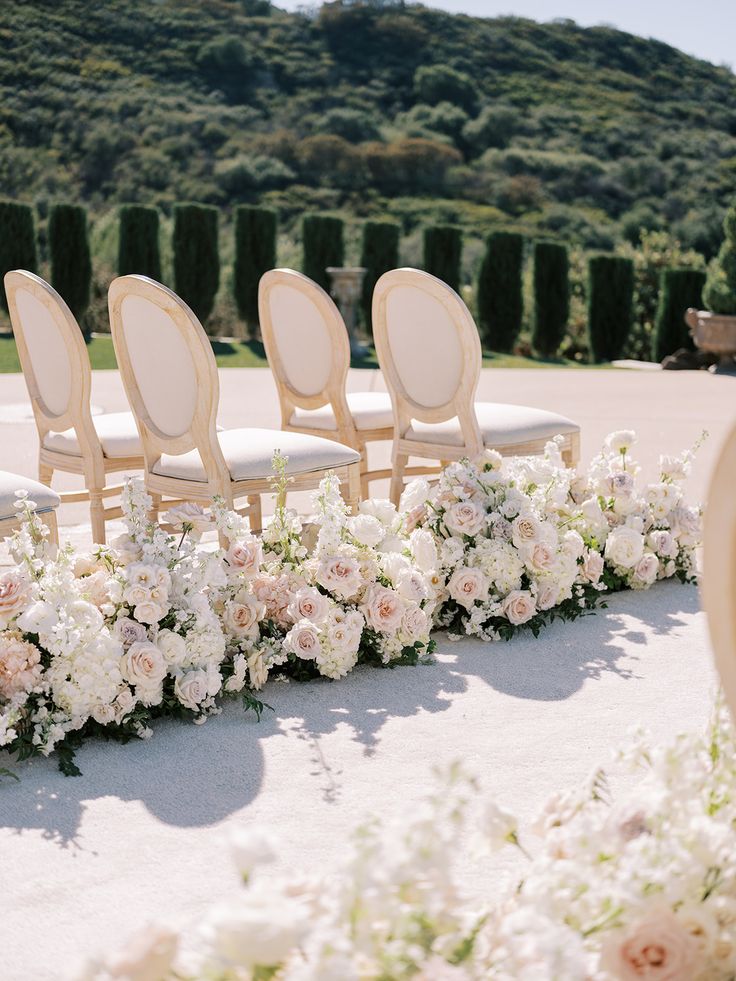 a row of chairs sitting next to each other near flowers