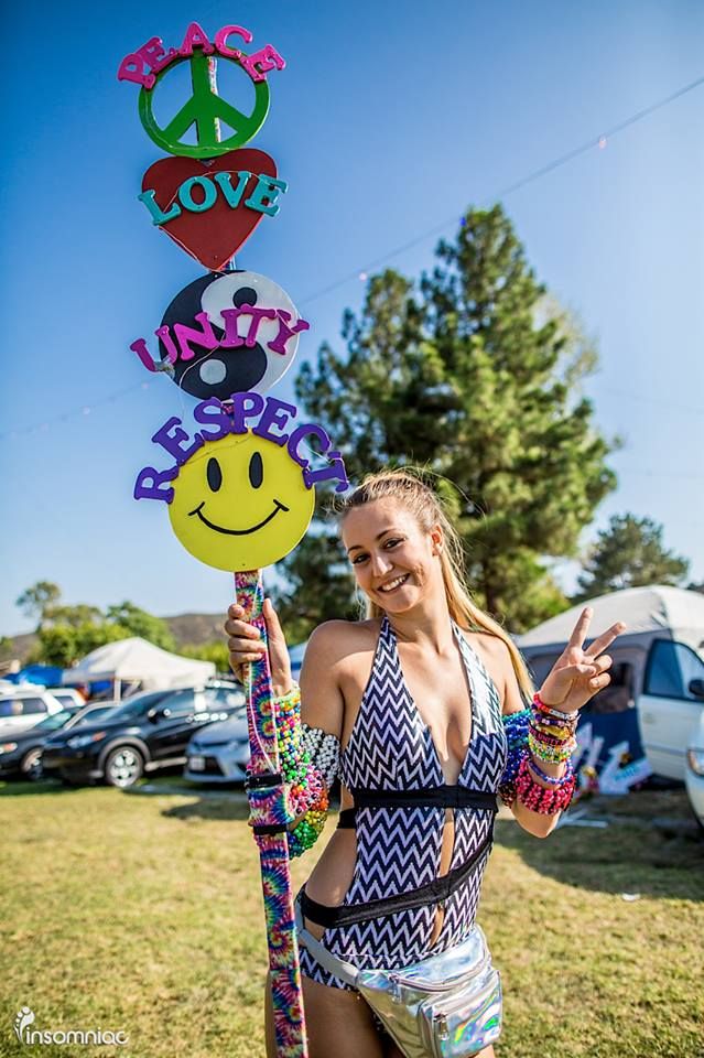 a woman in a bathing suit holding up a peace sign and smiley face pinata