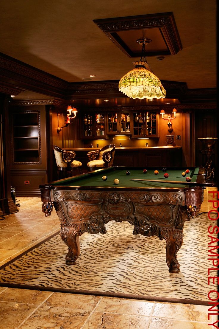 a pool table in the middle of a room with lights hanging from it's ceiling