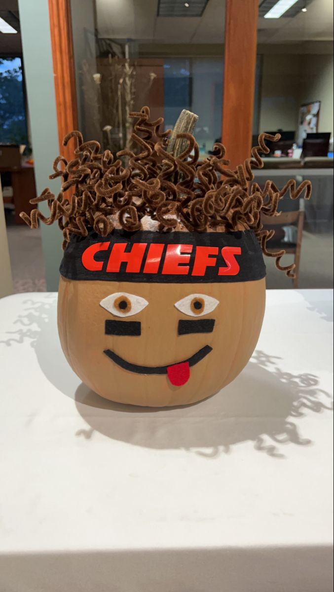 a carved pumpkin with a chef's hat on it sitting on top of a table