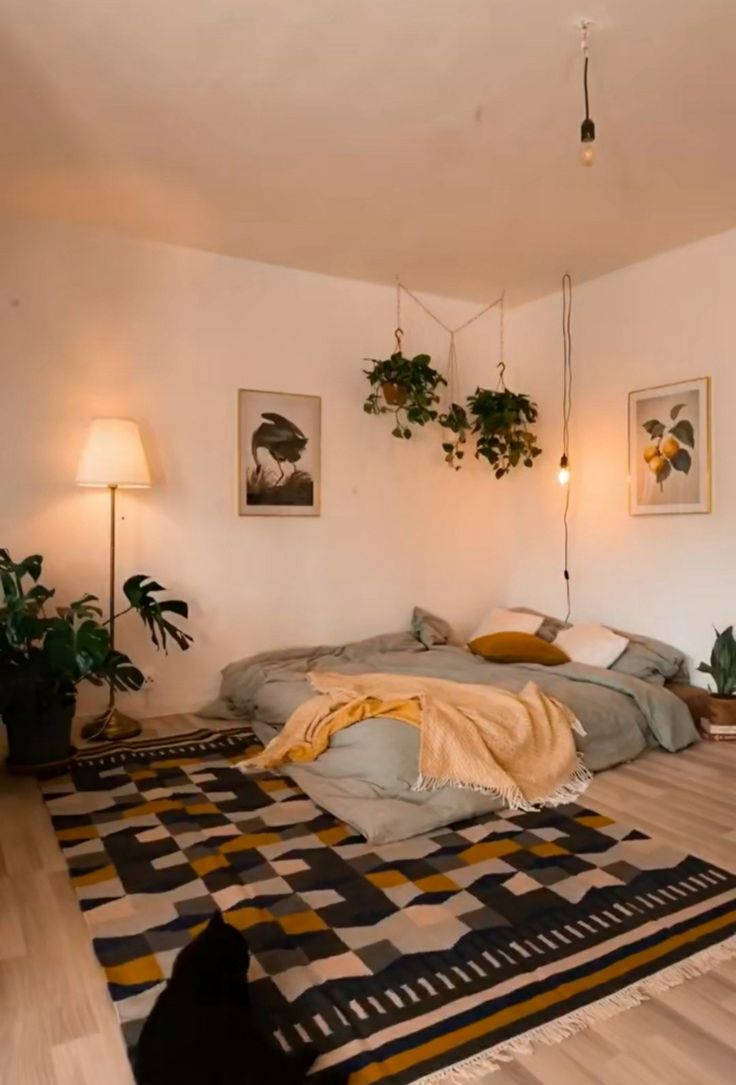 a bed sitting in the middle of a living room next to a wall mounted plant