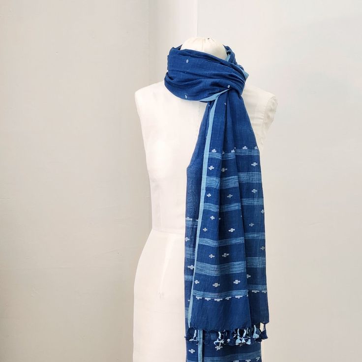 The softest cotton in the deepest indigo blue. Small jamdani-weave details in cotton and raw silk, with ikat-ish stripes at each end. handwoven and naturally dyed cotton with silk details 26.5 x 92 inches Jamdani handloom textiles are woven by hand, by master craftspeople, without the use of electricity. Designs are woven into the fabric while it is on the loom. Each piece is individually hand-crafted. Care: hand wash gently in cool water, line dry in shade. Bohemian Indigo Cotton Dupatta, Traditional Cotton Scarf With Natural Dye, Traditional Cotton Scarves With Natural Dye, Bohemian Blue Handloom Dupatta, Indigo Handloom Cotton Dupatta, Indigo Cotton Handloom Dupatta, Handloom Cotton Indigo Dupatta, Handloom Cotton Dupatta In Indigo, Blue Cotton Handloom Dupatta