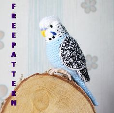 a crocheted bird sitting on top of a piece of wood with the words free pattern below it