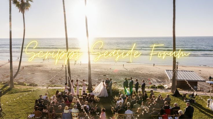 a group of people standing on top of a lush green field next to the ocean