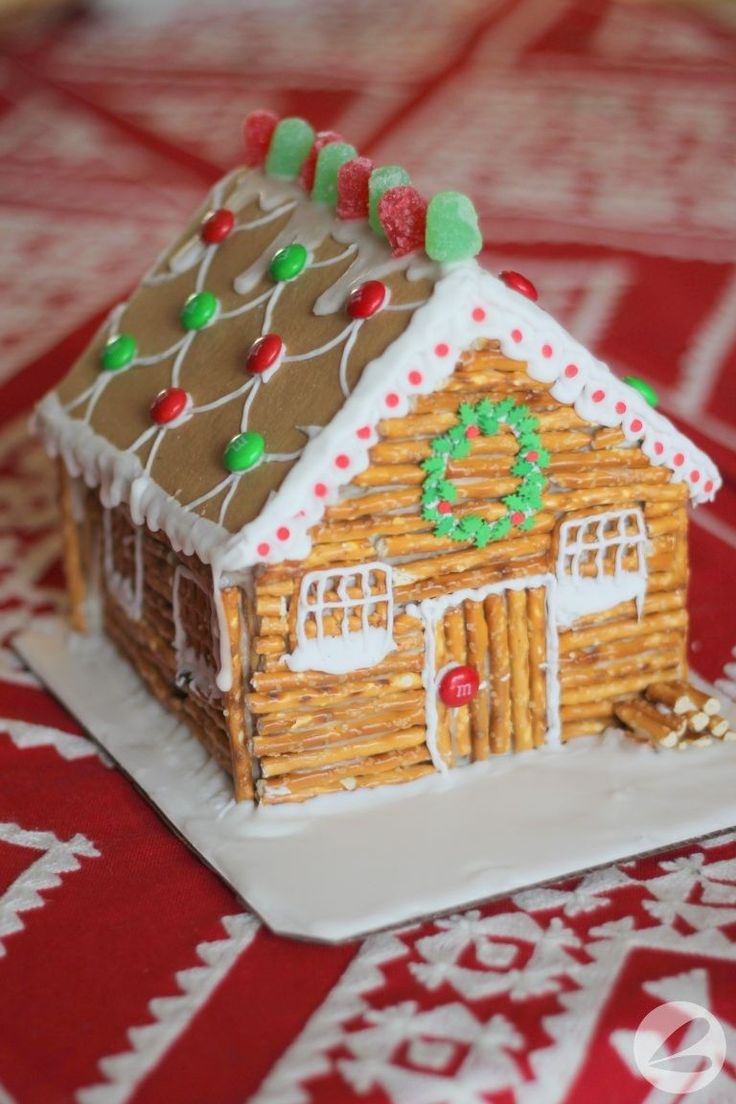 a gingerbread house is decorated with icing and candy canes on a plate