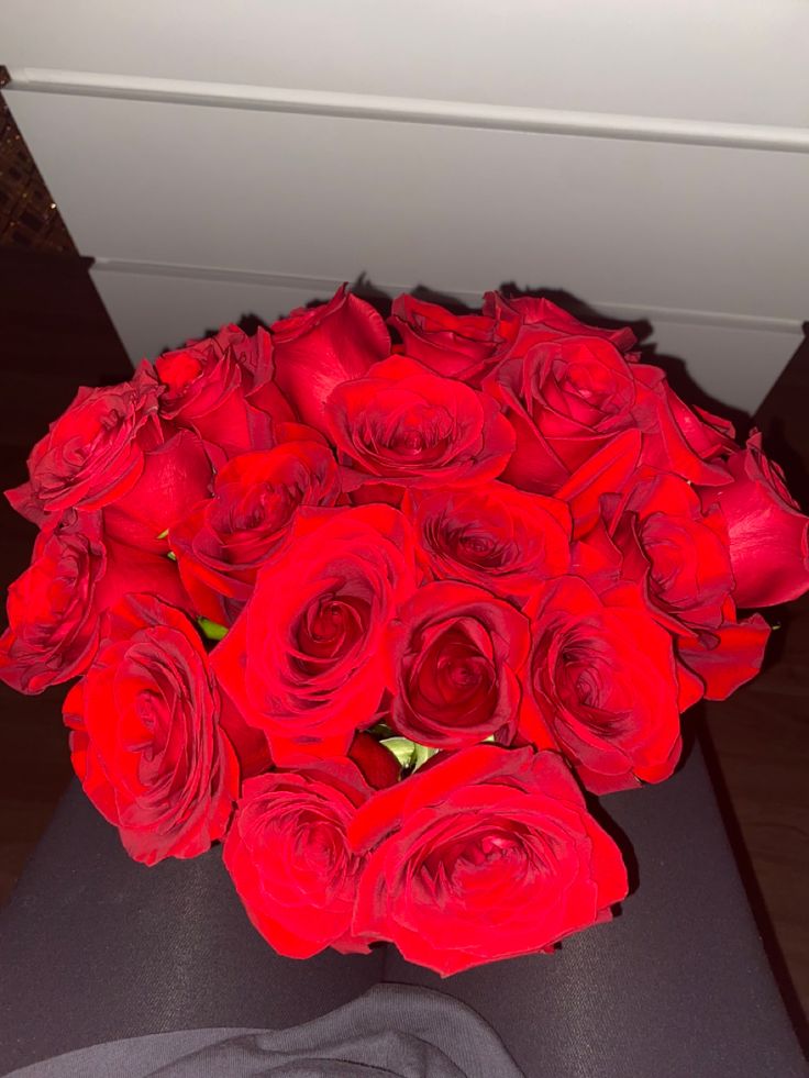 a bouquet of red roses sitting on top of a table