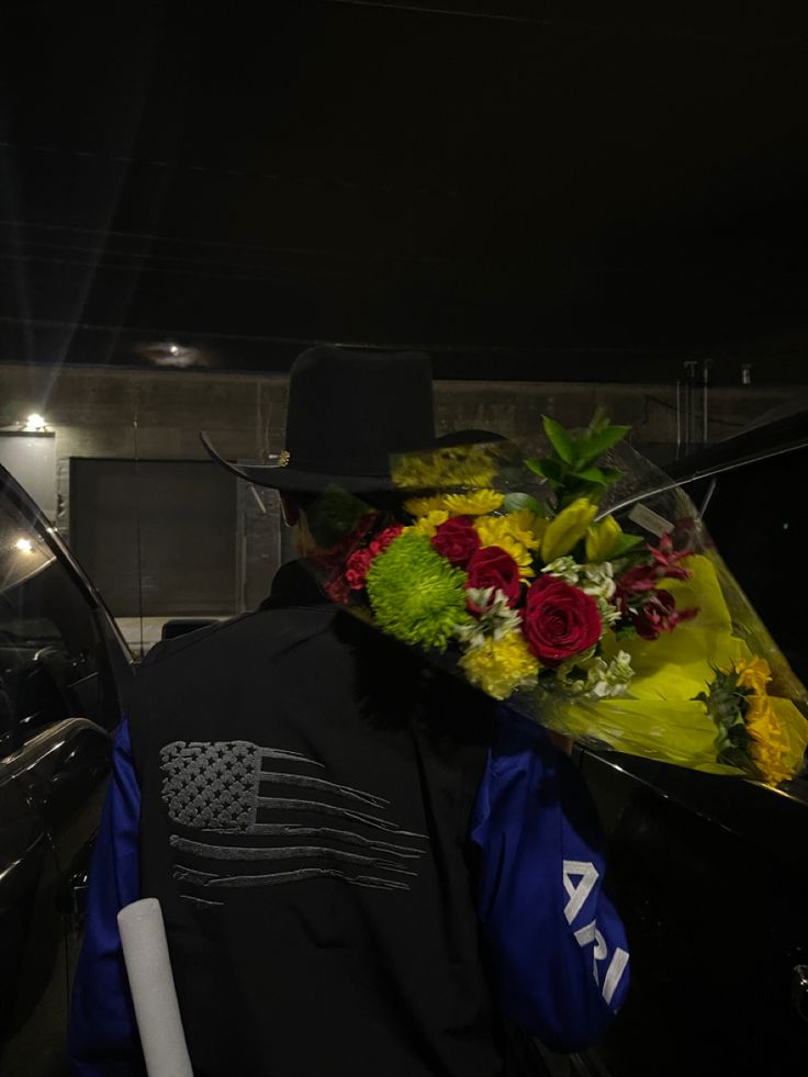 a police officer with flowers on his back in front of a car that is parked