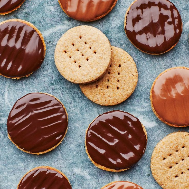 several cookies with chocolate frosting and peanut butter on blue paper lined up next to each other