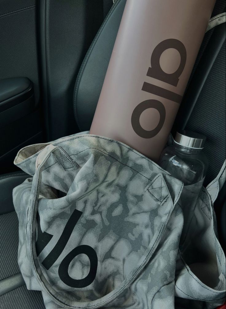 the back seat of a car with a water bottle and bag in front of it