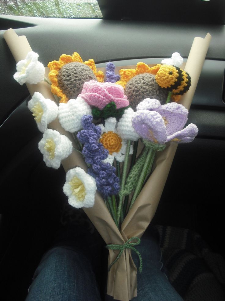 a bouquet of crocheted flowers sitting in the back seat of a car