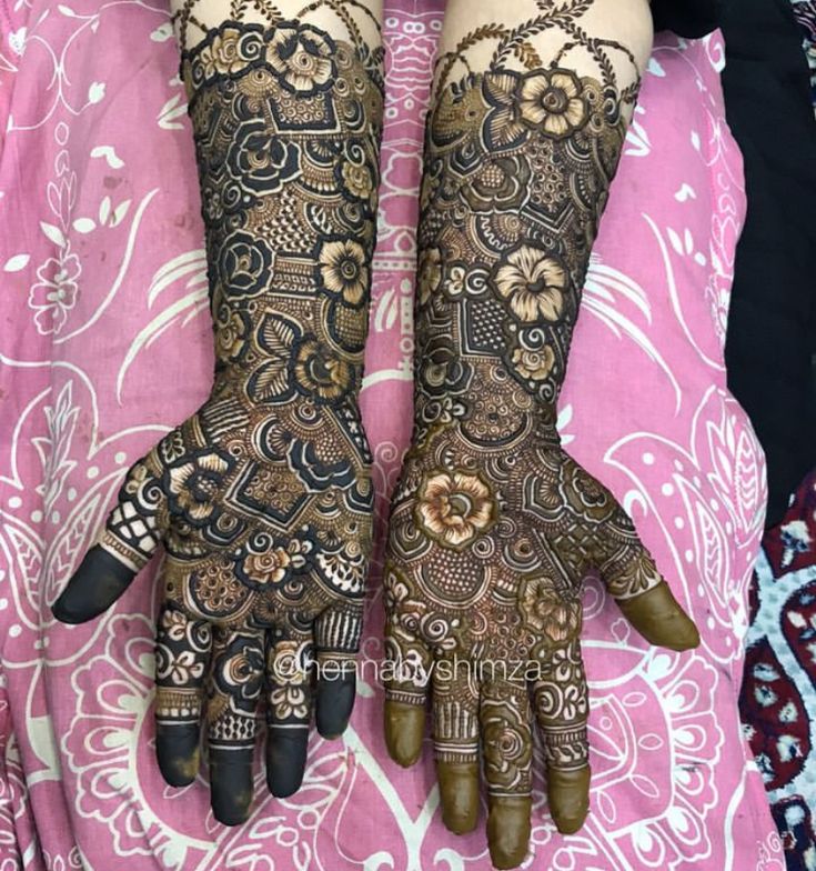 two hands with henna tattoos on them