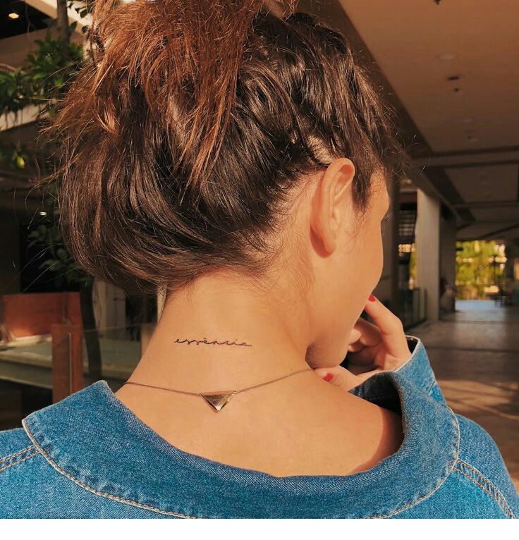 a woman with a small tattoo on her neck