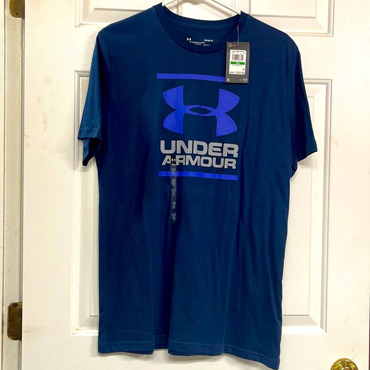 a blue under armour t - shirt hanging on a white door with a tag attached to it