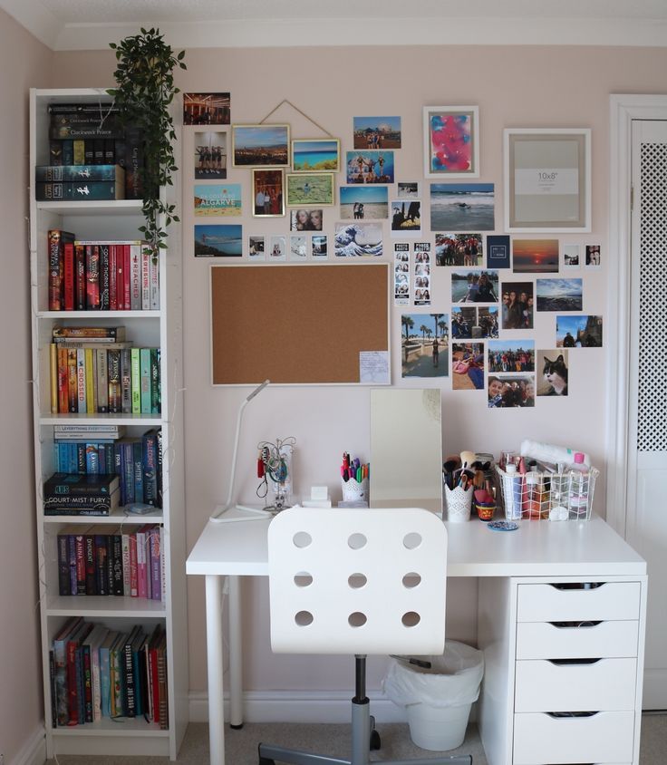 a white desk topped with a computer and lots of pictures on the wall behind it