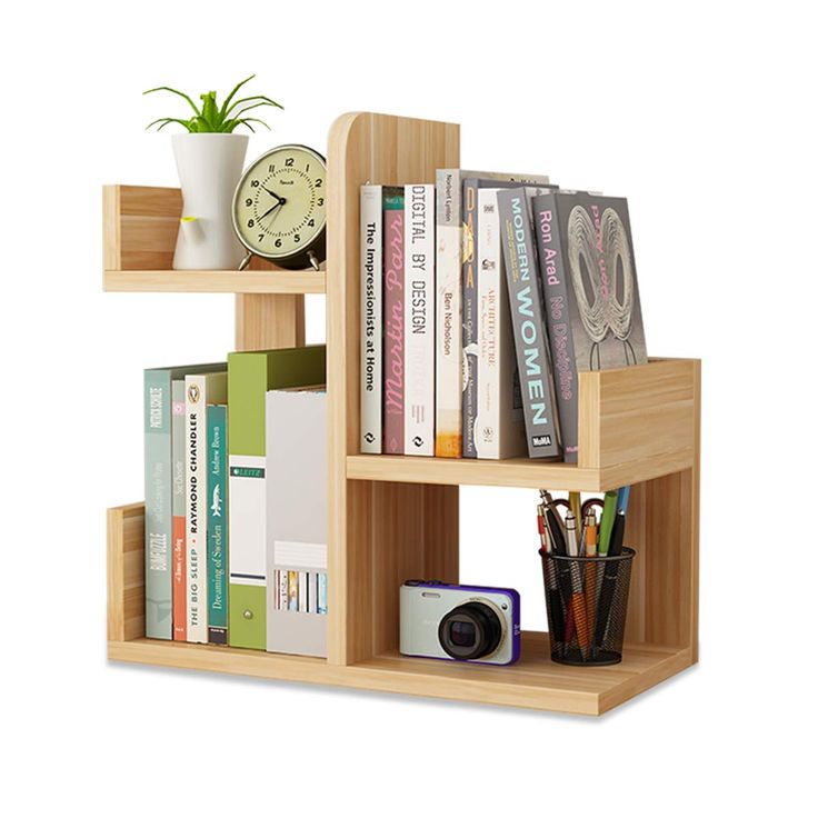 a bookshelf filled with lots of books next to a small plant and a camera