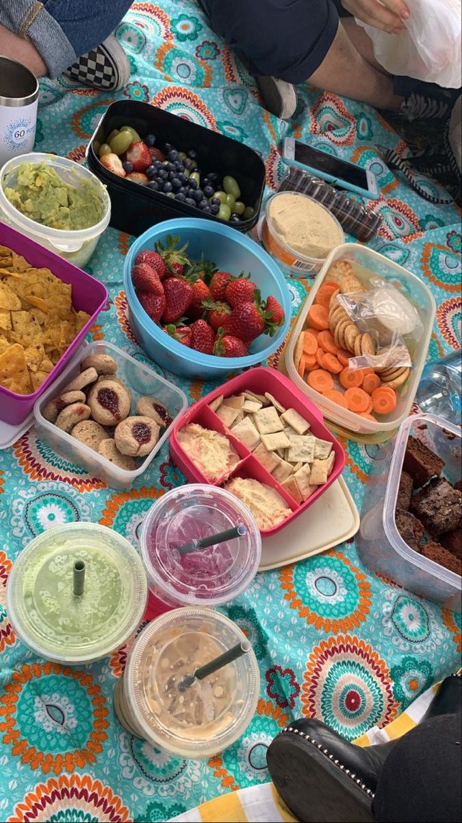 a table topped with lots of food on top of a blue and orange cloth covered table