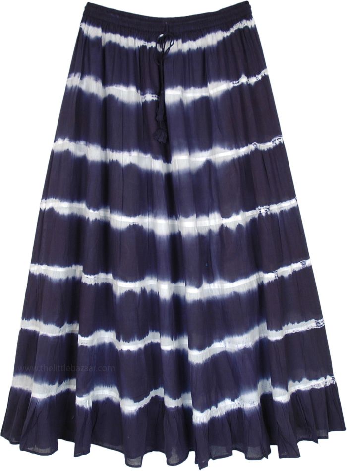 A light and breezy feminine long cotton summer skirt is exactly what you need for the season! With its harmonious balance of cool tones of ink blue, it is sure to bring glow to your face.  The skirt is in tie-dye pattern and has an elastic waist with drawstring for ease of comfort. #tlb #TieredSkirt #MaxiSkirt #vacationclothing #beachwrap #TieDye #CottonMaxiSkirt #TieDyeSkirt #SummerSkirt #BeachSkirt Flowy Cotton Beach Skirt, Flowy Cotton Summer Skirt, Indigo Bohemian Bottoms For Summer, Bohemian Indigo Bottoms For Summer, Cotton Tie Dye Skirt For Summer, Tie Dye Long Skirt For Summer, Tie Dye Tiered Skirt For Summer, Casual Tie Dye Skirt For The Beach, Casual Indigo Skirt For Summer