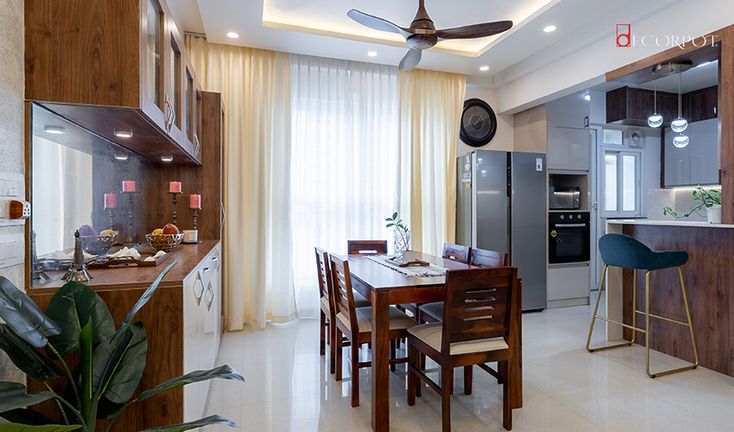 a kitchen and dining room with a ceiling fan in the middle of the room,