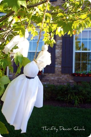 a ghost hanging from a tree in front of a house