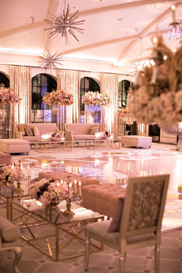 an elegant wedding reception with chandeliers and flowers on the tables in front of them