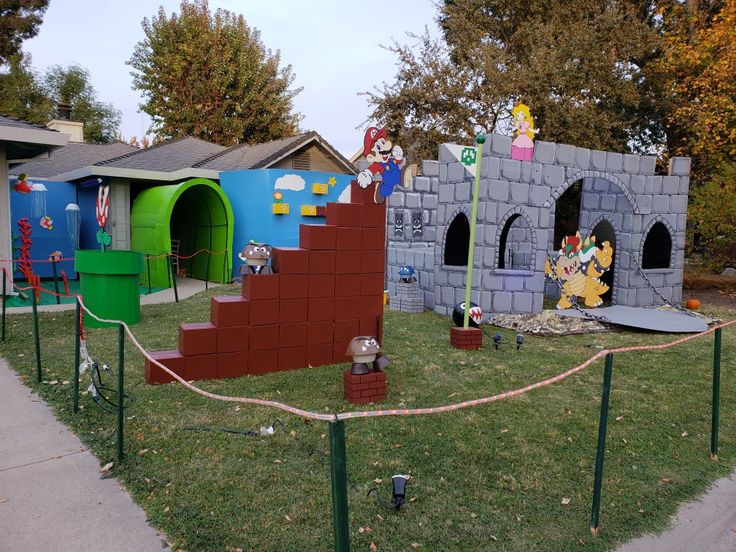 an outdoor play area for children with colorful walls and structures on the grass in front of them