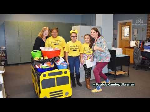 some people in yellow shirts are posing for a photo with their food and drink cart