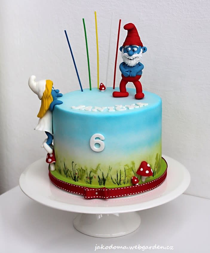 a birthday cake decorated with an image of the number six and two gnomes on top