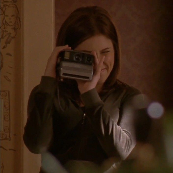 a woman holding up a camera in front of her face